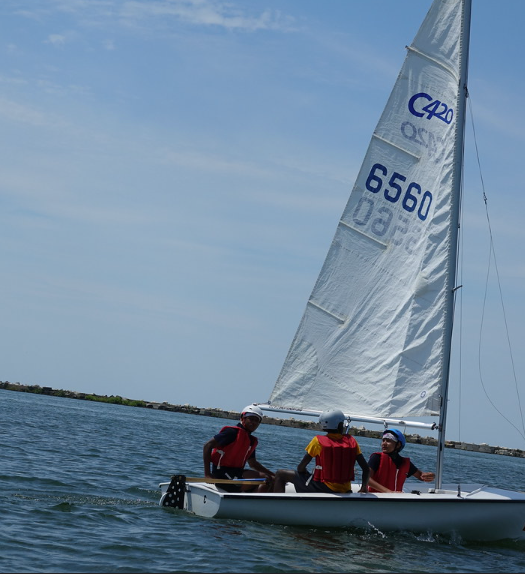 Three people sailing on a small boat