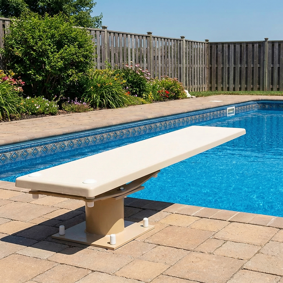 For the visually Impaired: This images centers around a creme colored bolt style diving board that has been set on a concrete style deck with an etched paver look. The diving board is at the edge of a pristine blue pool. There are an assorted variety of flowers bushes and other plants at the edge of the pool deck. In addition, there is a patch of lush green grass at the edge of the deck.