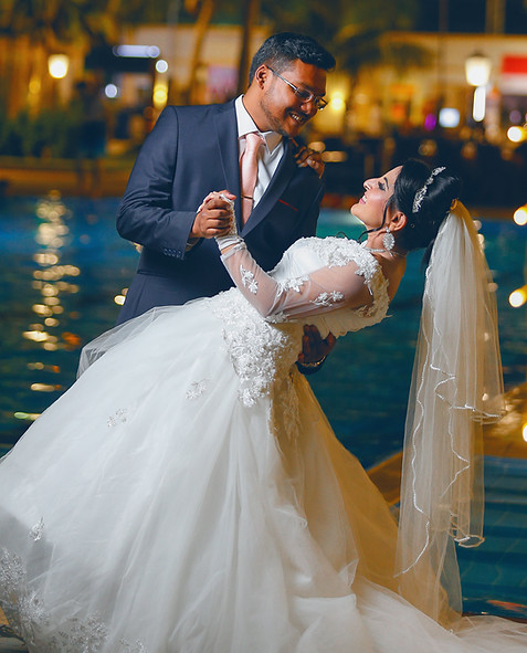 a couple doing a dance pose in front of the swimming pool of a hotel on their wedding day in london photography done by the wedding records.