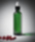 A dropper bottle of green liquid and red pills. black background..jpg