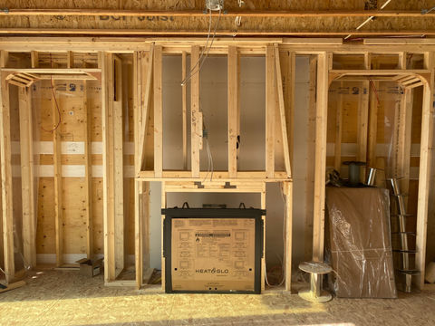 Framing structure of a permanent shelf unit and base of where a fireplace will be put 
