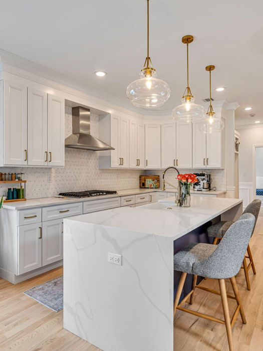 Modern luxury kitchen with quartz waterfall island, pendant lighting, and open-concept design in River Edge NJ home