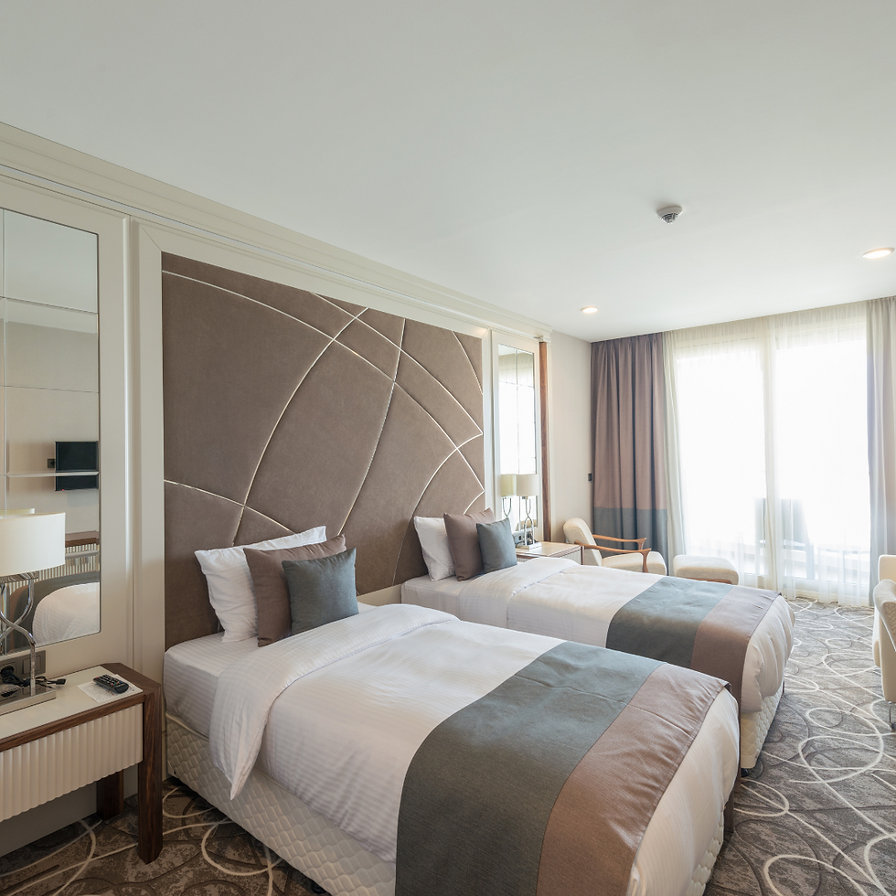 Attractive clean hotel room with large bright window and mirrors, 2 beds nicely made