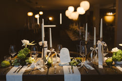 Eingedeckter Hochzeitstisch mit weißen Rosen und grün