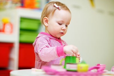 Adorable toddler girl playing with toys