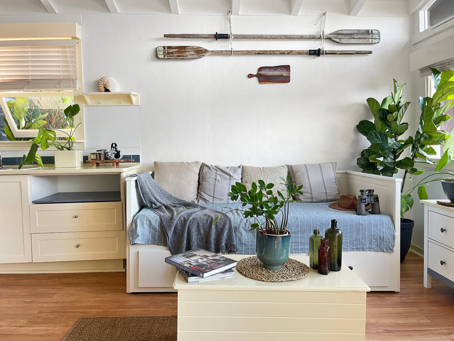 Daybed styled with vintage oars, binoculars, hat and green glass bottles