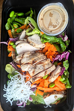 Colorful salad with lettuce, carrot, red cabbage, grilled chicken, crispy rice noodles