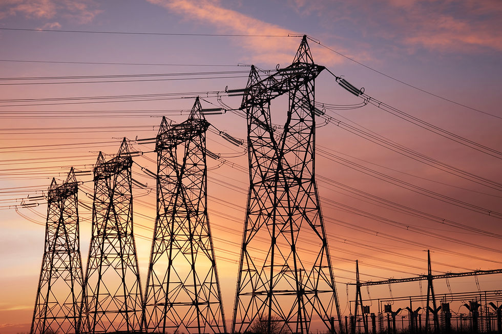 High-voltage power lines and towers at sunset.