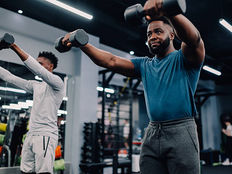 Pessoas fazendo exercício com halter na academia