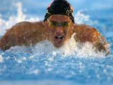 Homem nadando com acessórios de natação (touca e óculos)