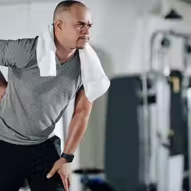 Homem sentindo as costas na academia 