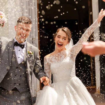 Noivos recebendo chuva de arroz no casamento. 
