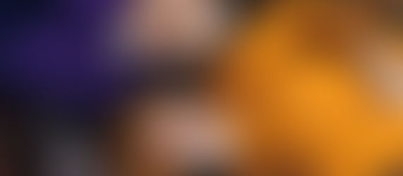 Pexels photo - Two people smile as they lie on the ground covered with autumn leaves. One wears an orange sweater and matching hat, while the other wears a purple sweatshirt. They both touch each other's cheeks in a cheerful and relaxed manner, with a white thermos beside them.