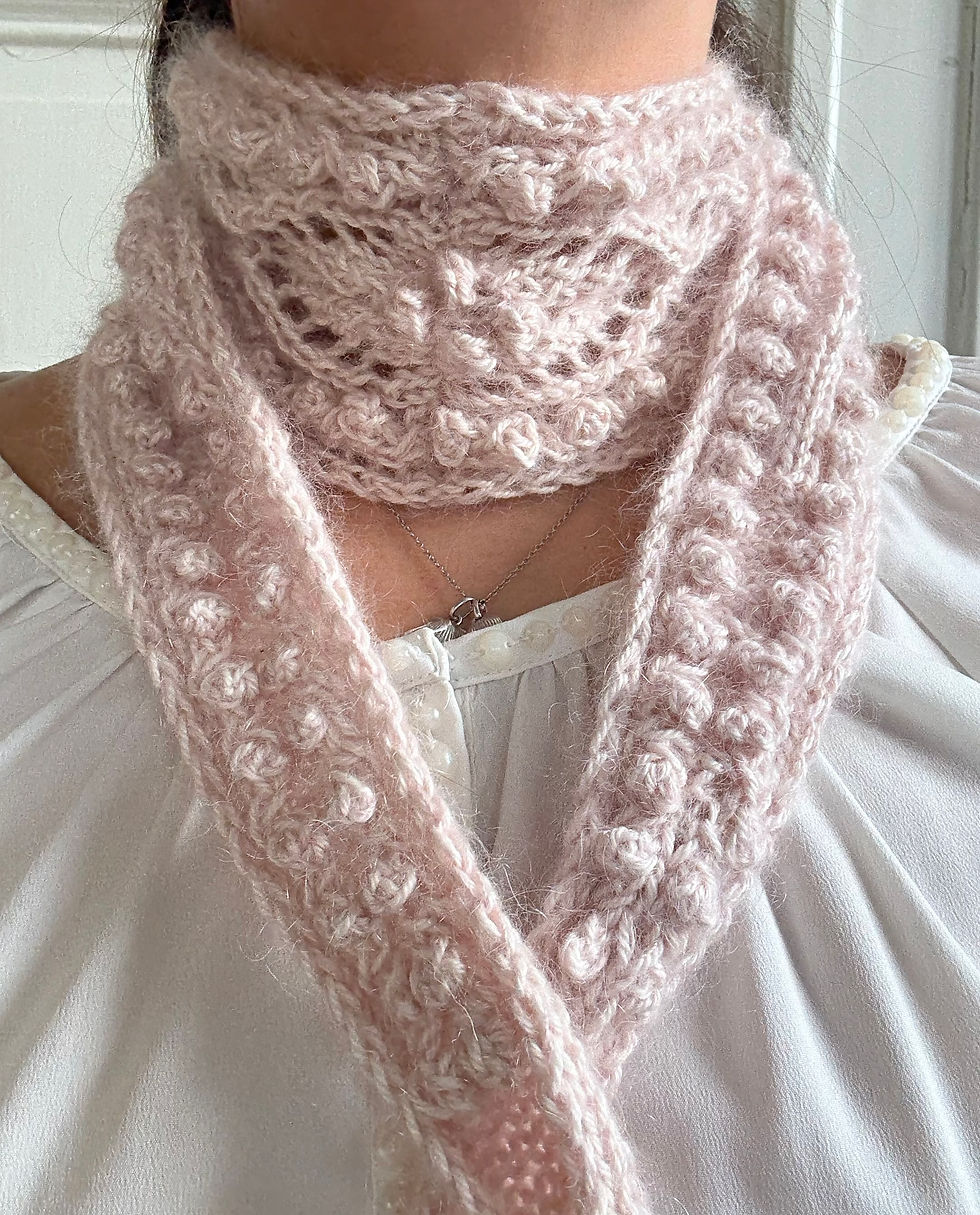 Thumbnail: Seashells Scarf by MyChicKnits — a feminine mini-scarf pattern by Marthe Øyrås with textured lace and bobble details.