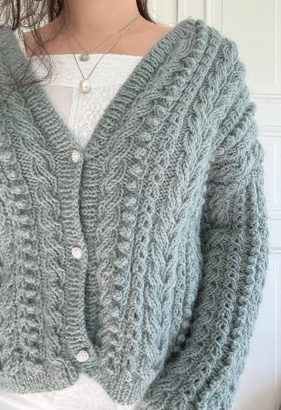 Thumbnail: Frostberry Cardigan by MyChicKnits — a textured knitting pattern by Marthe Øyrås with cables and bobbles.