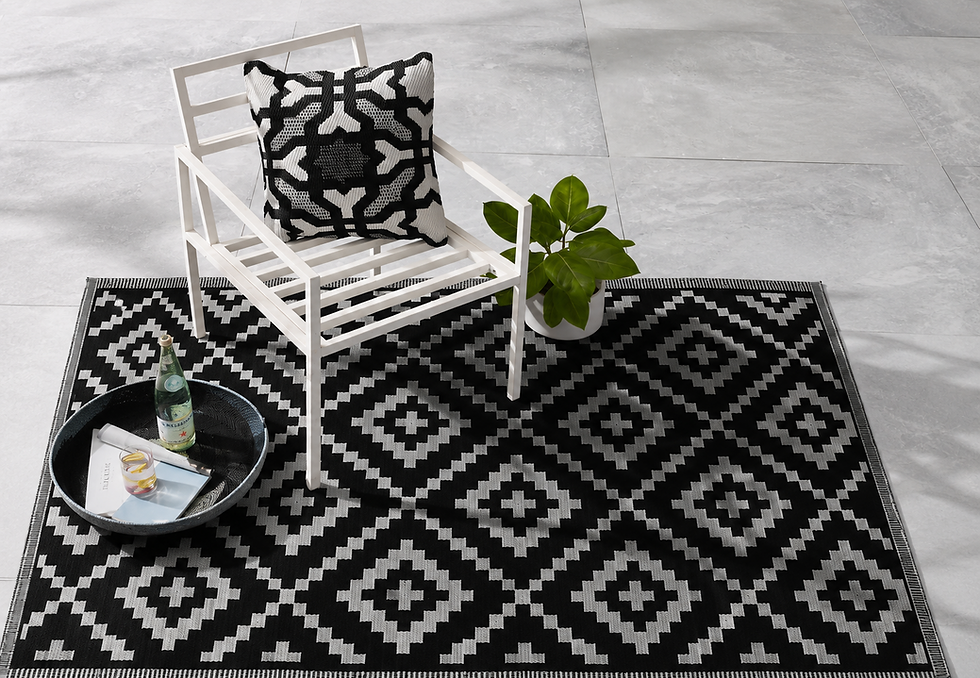 Black and white diamond pattern polypropylene outdoor rug under a patio chair, Streamflow Jalgaon