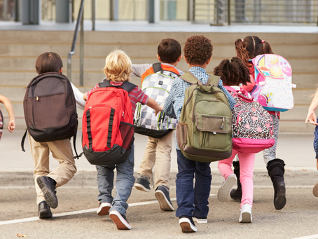 Bambini con gli zaini che camminano verso scuola