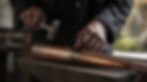 Macro, cinematic close-up of a Japanese master coppersmith’s hands during the _annealing a