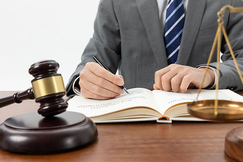 closeup-shot-of-person-writing-in-book-with-gavel-on-the-table (2).jpg