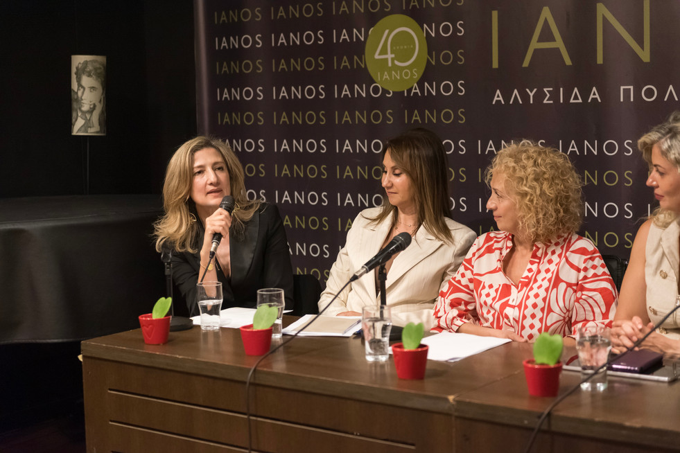 Christina Charokopou sitting next to her friends and fellow alumnae guest speakers, thanking them and the audience at the presentation event of her Concept Book titled "APHRODITE REINVENTED® - Η ΑΦΡΟΔΙΤΗ ΠΟΥ ΕΠΑΝΕΦΗΥΡΑ" at IANOS Bookstore Athens, June 2nd, 2026