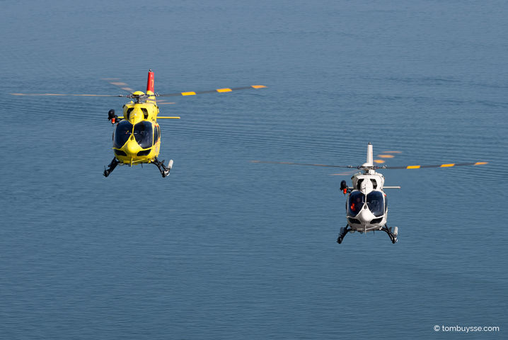 Twee Airbus H145 helikopters van NHV in formatie boven de Noordzee bij Midden-Zeeland tijdens air-to-air fotografie.