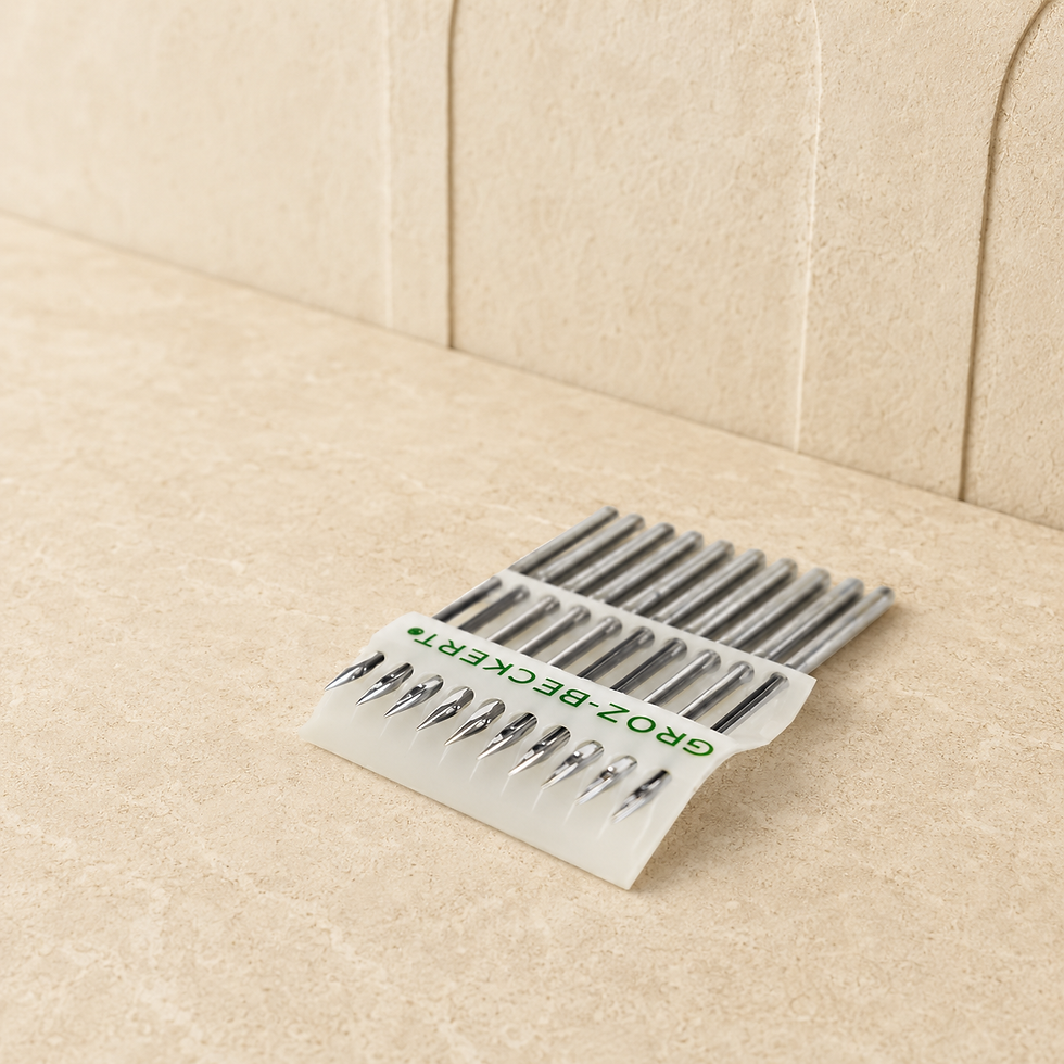 Thumbnail: Close-up of Groz-Beckert DB x K5 RG embroidery machine needles in a branded card on a warm stone background.