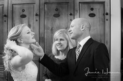 Black and white image of a groom and flower girl smiling at the bride during the ceremony.