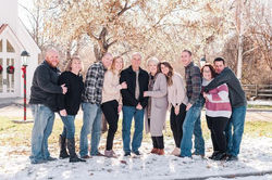 A group of ten people standing outdoors in a snowy landscape with bare trees.