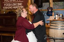 Bride and groom dancing closely in a rustic indoor setting.
