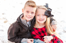 A close-up of a young boy and girl smiling and embracing.