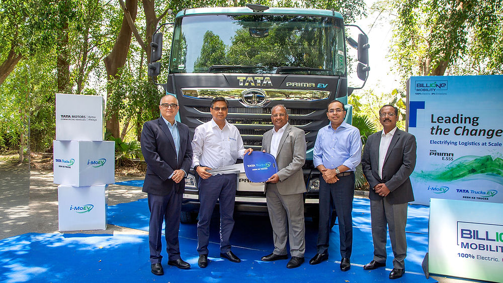 Executives with Tata Conceptron EV truck, marking new transport