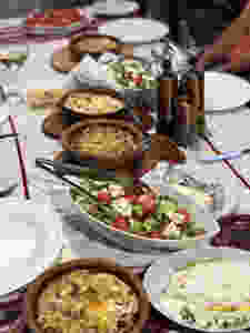 A table set with lots of plate and tons of food.