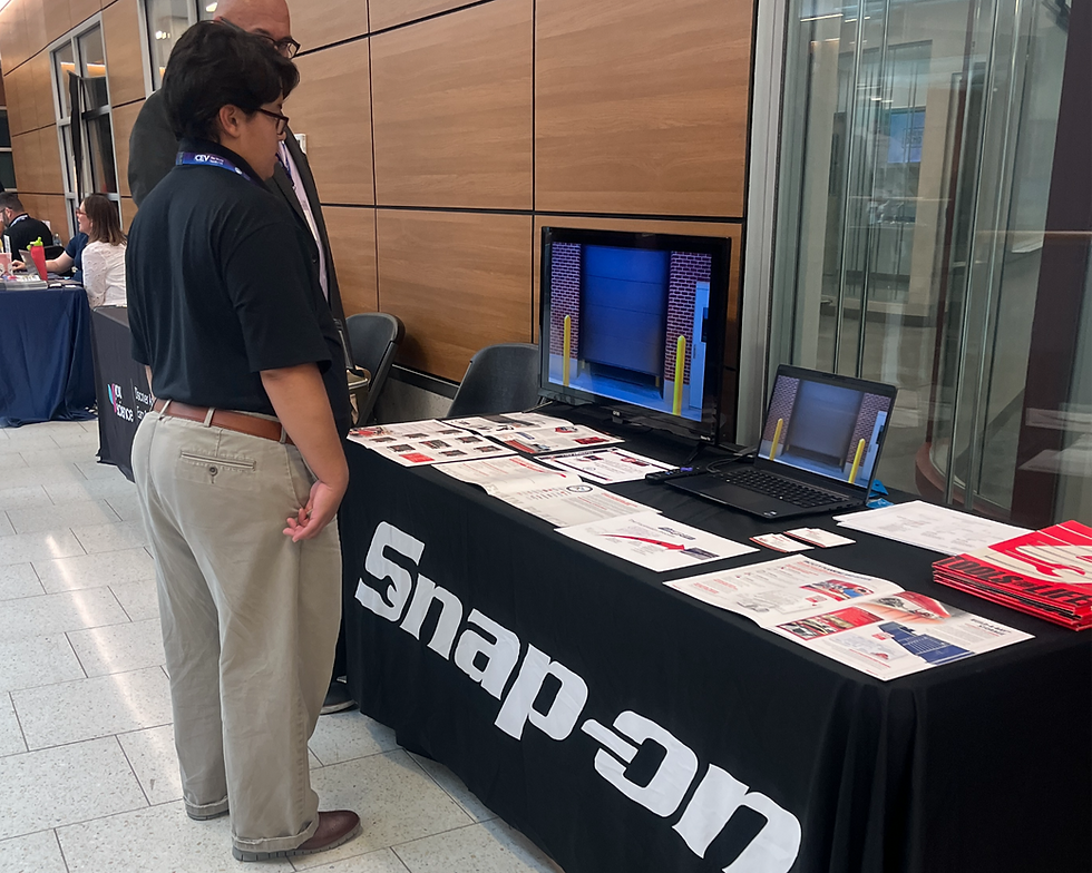 Marco Taverner, Community Engagement Coordinator for the NCNGM, listens to a Snap-On representative discuss their career technician education offerings, including equipment for educational institutions.
