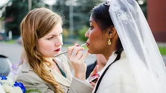 Photo d'une coiffeuse-maquilleuse professionnelle en train de réaliser le maquillage de mariage d'une future mariée