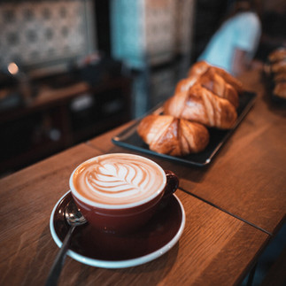 tasse mit esspresso macchiato und einem Crossaint
