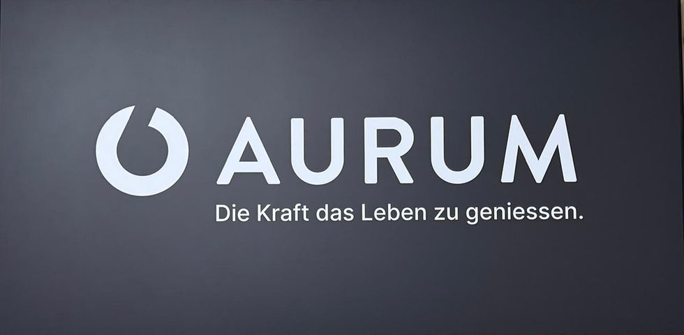 Grauer Hintergrund mit weißem AURUM-Logo und dem Slogan Die Kraft das Leben zu geniessen.