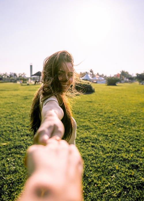 Woman holding hand of someone and smiling