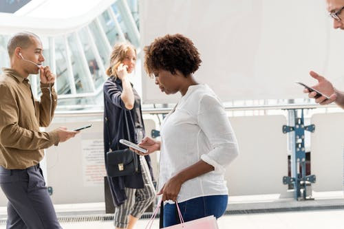people walking and talking with their digital devices
