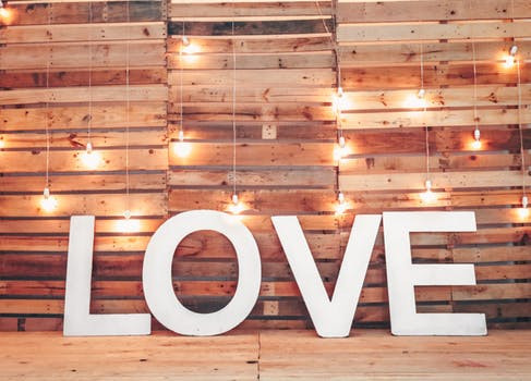 Sign of LOVE in front of a wood picket wall