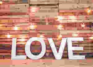 Sign of LOVE in front of a wood picket wall