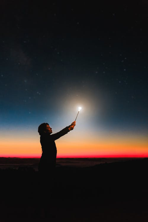 woman in the dark with a wand