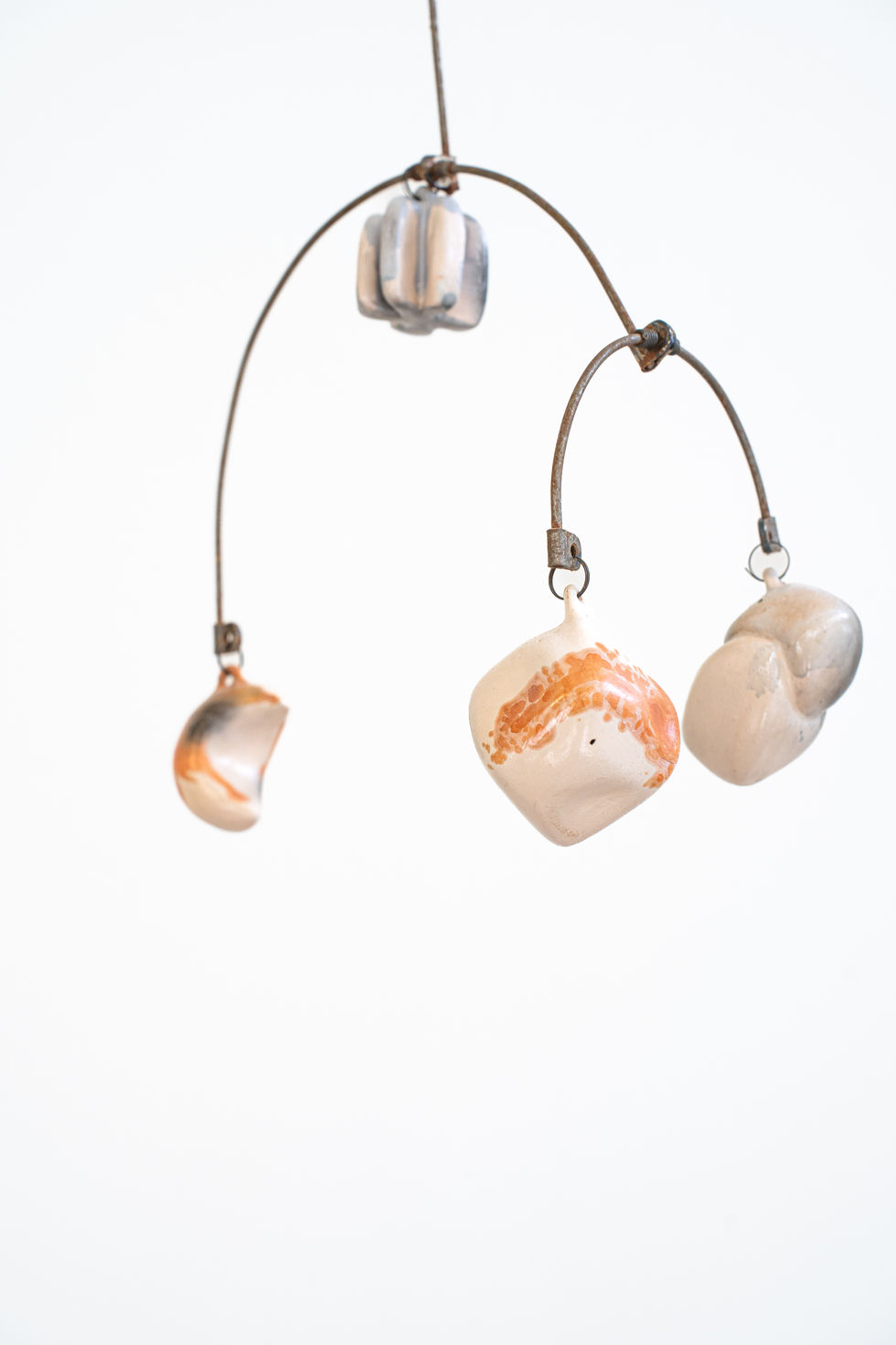 Kinetic Sculpture, saggar fired ceramic pieces suspended from metal strings.