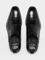 Black cap-toe oxford dress shoes with sleek leather uppers, precise stitching, and matching black soles (top view shot)