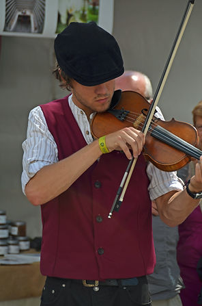 Fiddle player wearing a waistcoat and flat cap
