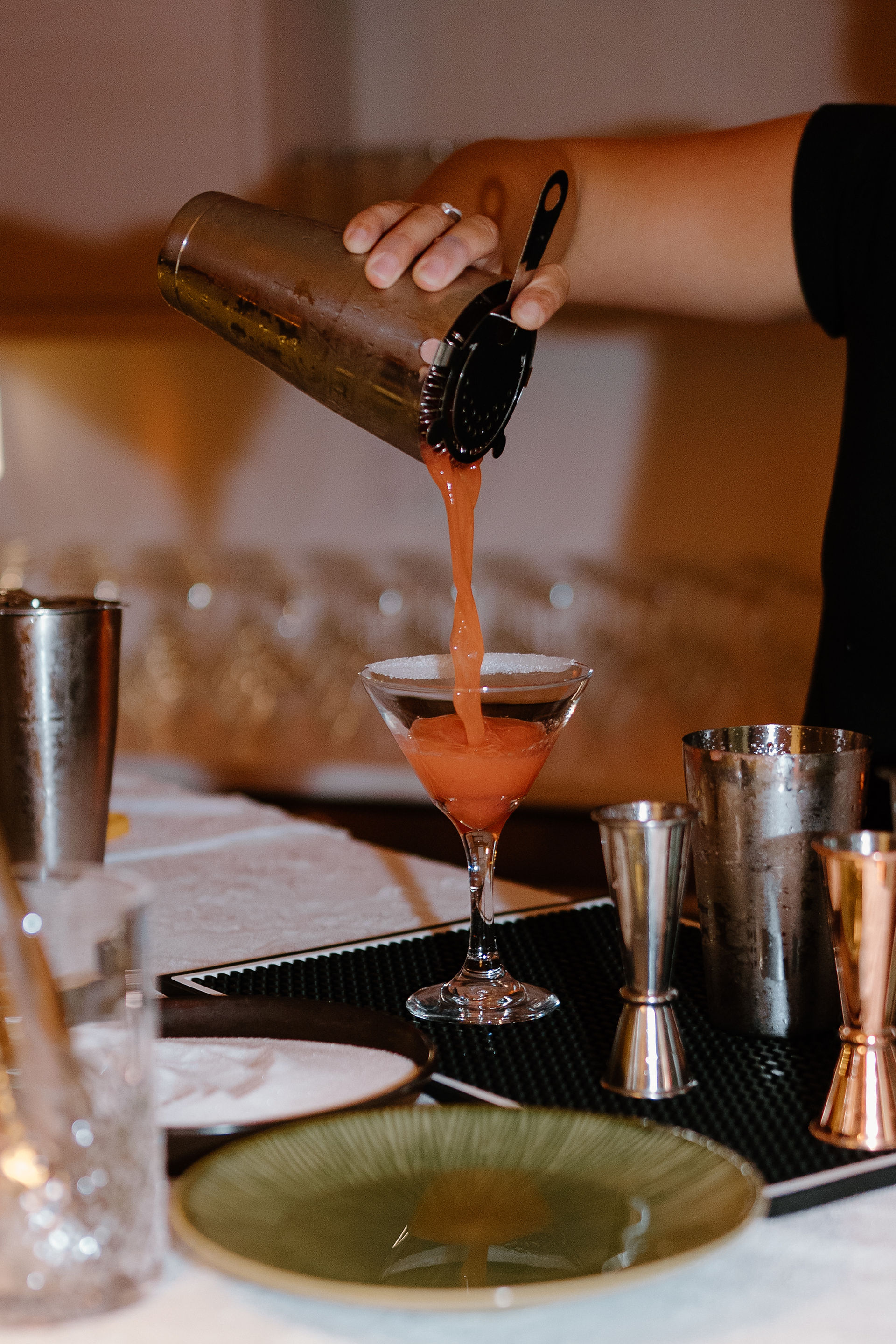 Bartender pouring a cocktail into a martini glass at a luxury brand launch party in Kirkland Seattle