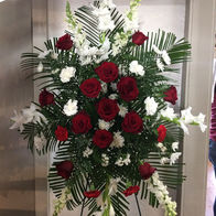 Funeral easel arrangement with red and white flowers and greenery