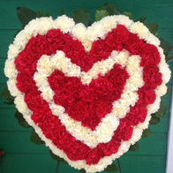 A fully filled heart-shaped wreath of red and white flowers