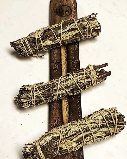 A trio of yerba santo bundles on a beautifully carved incense tray.