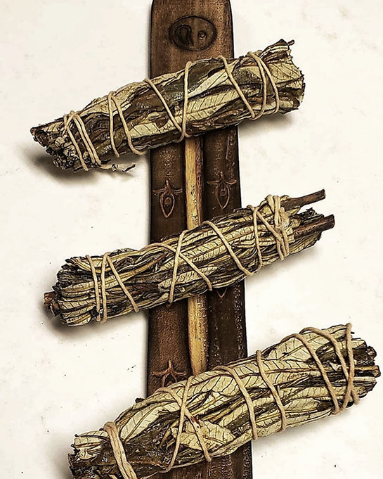 A trio of yerba santo bundles on a beautifully carved incense tray.