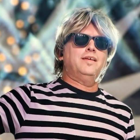 Man with blonde hair, sunglasses, and striped shirt